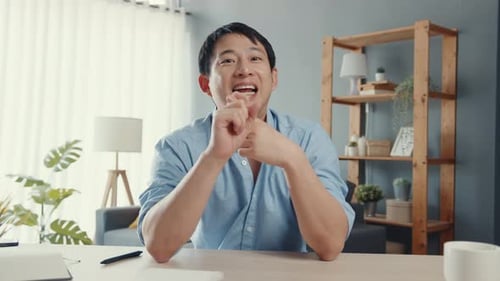 Smiling Man Explains Concepts in Home Office Setting