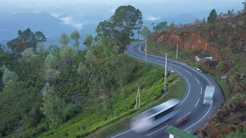 Diferentes coches conducen por una sinuosa carretera de asfalto gris