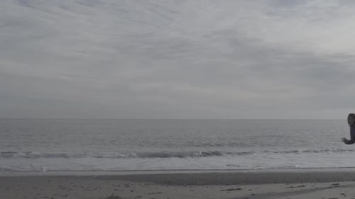 A young woman running on the beach.