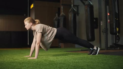 Strong Female Boxer Standing in Plank in Sport Club. Fit Girl Warming Up at Gym