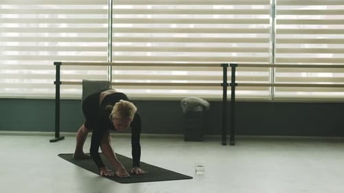 Woman Practices Yoga Poses in Studio