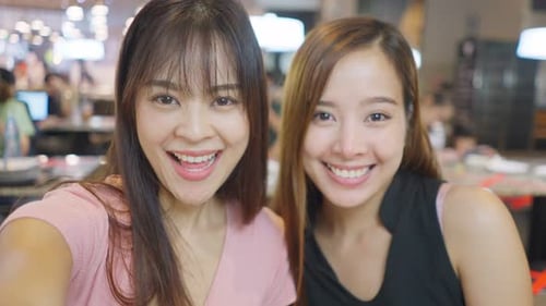 Point of view Asian young girls making a online video call on smartphone with their friend in store.