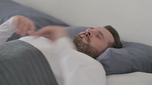 Homme se réveillant de son sommeil dans son lit