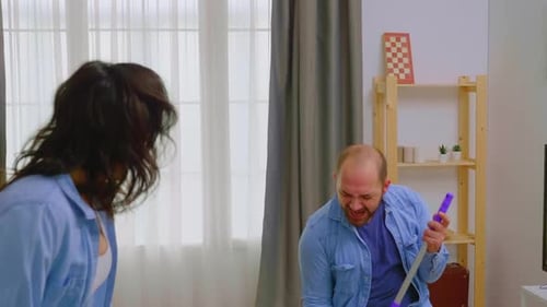 Man and Woman Having Fun While Cleaning