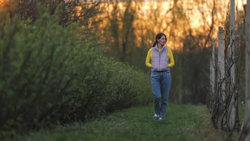 Woman Walking on Rural Path at Sunrise