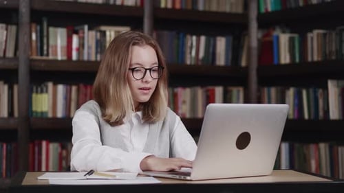Girl Using Laptop for Video Call in Library
