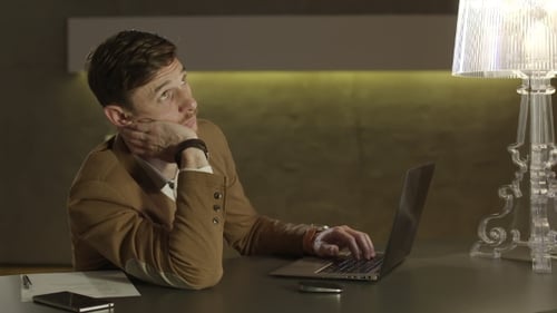 Man Working at Desk Using Laptop Computer