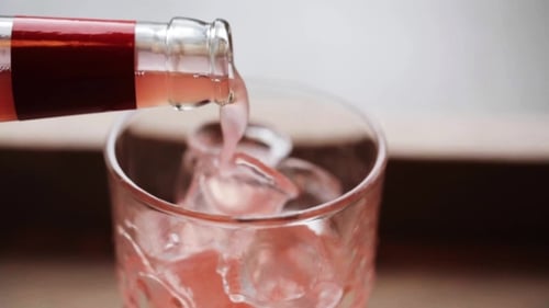 Refreshing Pink Soda Being Poured Over Ice