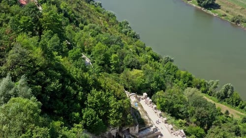 Aerial view on the tower of the castle located on a top of a hill. Beautiful river flows below.
