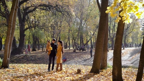 Happy Family With a Baby In Autumn Woods