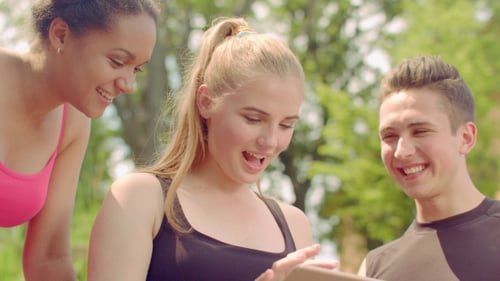 Young People Having Fun Together With Tablet Computer. Happy Friends Smiling