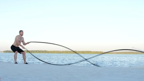 Training mit Seilen auf einer sandigen Bank in der Nähe des Wassers