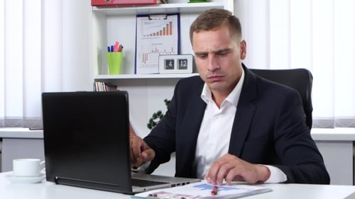 Focused Man Working at Desk in Modern Office