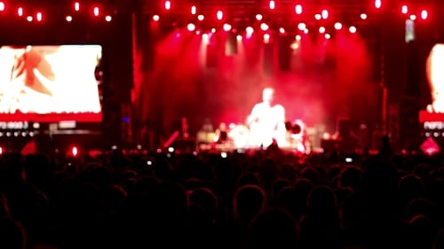 A Crowd Of People At a Concert, a Show Of Hands Waving, Clap Rock Musicians On The Brightly Lit