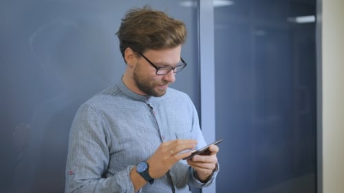 A Young Man Standing In The Hallway In The Office.