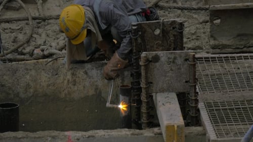 Worker Operating With Gas Jet To Cut Metal Pipe