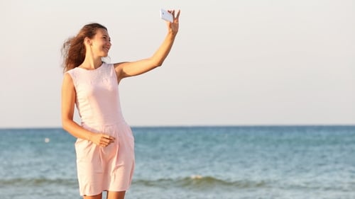 Woman Taking Selfie on Sunny Beach Vacation