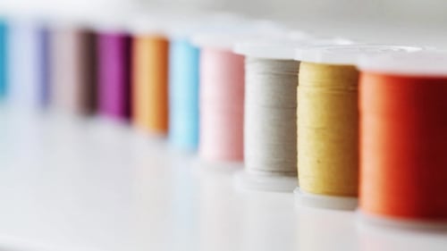Row Of Colorful Thread Spools On Table 1