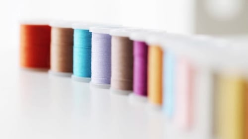 Row Of Colorful Thread Spools On Table 2