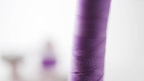 Purple Thread Winding Onto a Bobbin Spool