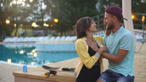 Pareja feliz junto a la piscina