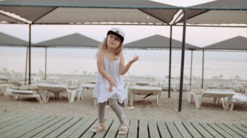 Little Girl Dancing In Evening Pebble Beach, Sea In Background
