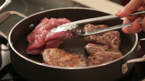 Raw and Cooked Meat in Frying Pan
