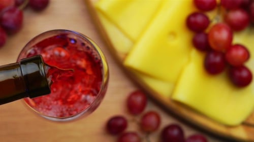 Pouring Rose Wine with Cheese and Grapes