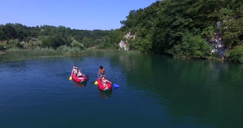 Aerial view of friends having fun paddling canoe