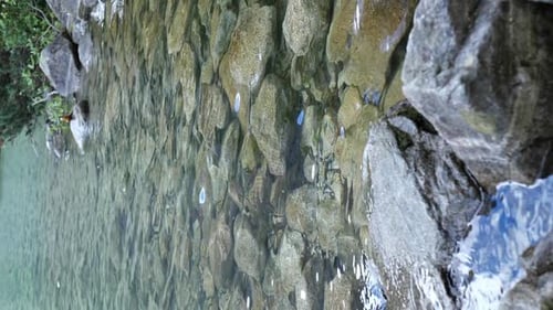 Slow motion footage of mountain water flowing over rocks. Natural lakes and waterfalls in the mounta