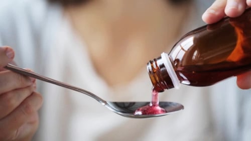 Mujer vertiendo medicación a cuchara