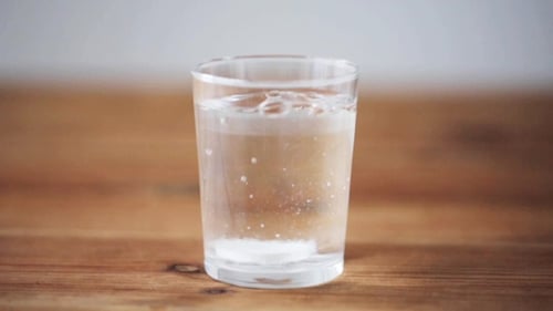 Effervescent Tablet Dissolving in Clear Glass of Water