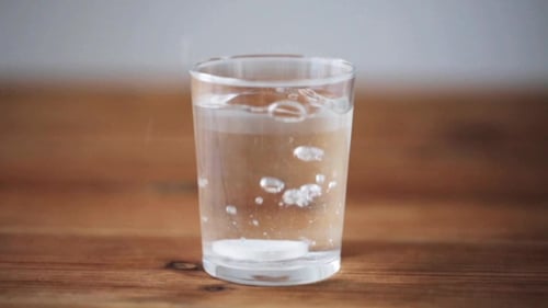 Effervescent Tablet Dissolving in Glass of Water