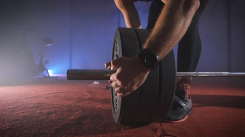Young Athlete Coming To The Barbell, And Adds To It The Weight.