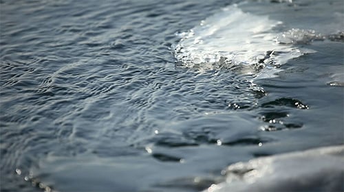 Water Ripples Down Small Creek with Ice