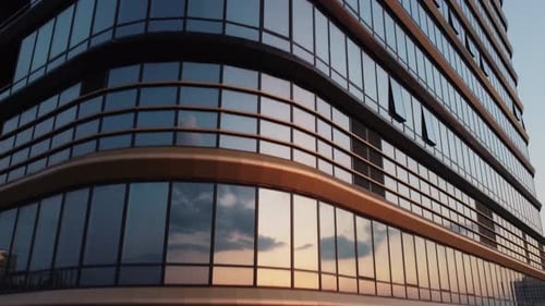 Langsame Kamerabewegung entlang eines modernen Glasgebäudes nach oben.