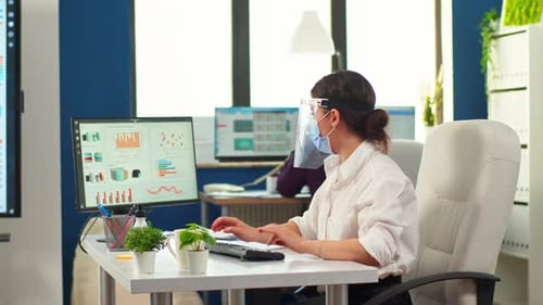 Woman Working in Office with Face Shield and Mask
