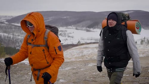 Hikers Trekking Across Cold Snowy Hilltop