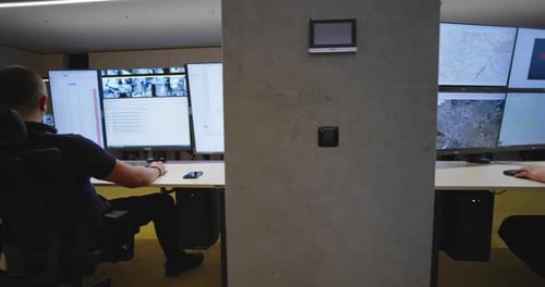 Security Guards Monitoring Modern CCTV Cameras in Surveillance Room