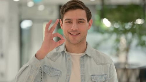 Cheerful Young Adult Man Giving Ok Hand Gesture