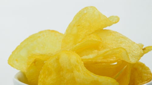 Bowl of Golden Potato Chips on White Background