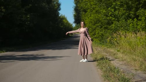 Woman Hitchhiking on Country Road on Sunny Day