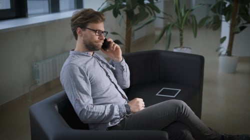 Man Talking on Mobile Phone Sitting on Couch