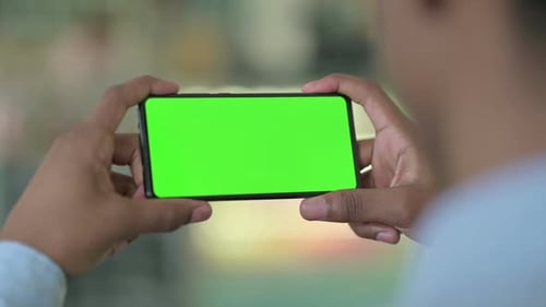 Rear View of African Man Looking at Smartphone with Chroma Screen