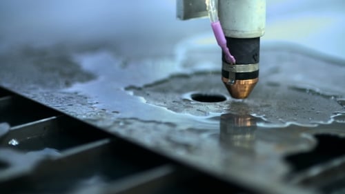 CNC Plasma Cutter That Is Cutting Out Metal Objects In a Heavy Industry Factory.