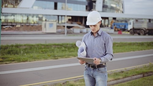 The Architect In a White Helmet Using a Tablet Computer At a Construction Site.