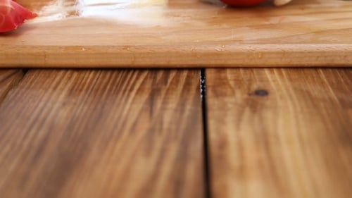 Close Up Cutting Tomatoes on Wood Board