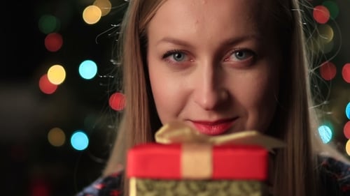 Woman Holds Christmas Gift Box Near Christmas Tree