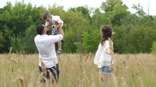 Happy Family Playing in a Grassy Meadow