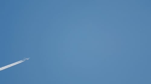 Airplane Flying High With White Contrail in Sky